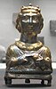 A silver statue of a lady with gold inlay. She appears to be wearing a crown.