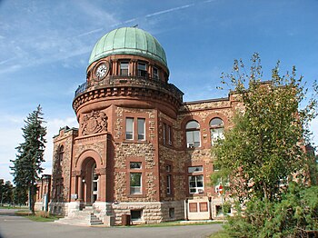 The Dominion Observatory building in Ottawa. A Romanesque Revival stone building with a prominent green dome.
