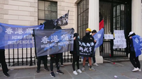 10多名身穿黑衣的在英港人示威者，于大使馆门外展示“光复香港，时代革命”和“香港独立”旗帜