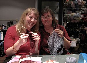 Two women knitters with blogs, holding up thei...