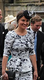 Pippa Middleton tersenyum mengenakan gaun hitam dan putih.