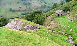 Ravine on hillside with ruined building