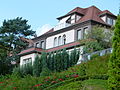 Villa mit Eingangspavillon und großzügiger Gartenanlage