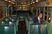 बस में बैठे अमेरिकी राष्ट्रपति बराक ओबामा। पार्क्स को उसी पंक्ति में बैठे हुए गिरफ्तार किया गया था जिसमें ओबामा हैं, लेकिन दूसरी दिशा में।