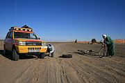 Local touaregs assisting a rally participant with a flat tyre on one of the Moroccan stages of the Budapest-Bamako