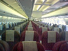 Interior of a Qatar Airways Airbus. Video systems (the vertical white panels) are visible above the very centre seats of the aircraft Flight-interior.jpg