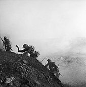 Gurkhas of the 4th Indian Infantry Division advance up a steep slope, 16 March 1943. Ghurkas advance through a smokescreen up a steep slope in Tunisia, 16 March 1943. NA1096.jpg