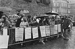 Ongeveer dertig demonstranten staan achter dranghekken op het Binnenhof terwijl het regent. Op spandoeken staat onder meer "Laat de vrouw niet het kind van de rekening worden" en "Geen komprommissen, de vrouw moet beslissen".