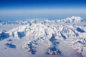 Im Vordergrund Mount Logan, rechts im Hintergrund Mount Saint Elias, dazwischen strömt der Sewardgletscher nach Osten (im Bild nach links).