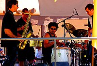 A modern salsa band lineup including less traditional salsa instruments such as a saxophone and a full drumset.