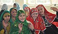 Hazara girls (right) wearing red traditional dress sitting next to Tajik and Pashtun girls in Ghazni, Afghanistan.