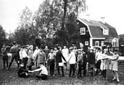 Stäketskolan med barn i förgrunden och skolbyggnaden i bakgrunden, 1927-1928.