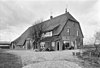 Grote boerderij. Woonhuis en stal onder een hoog rieten wolfdak. In de woongedeelte, dat rechts een opkamer heeft, ontlastingsbogen. In de linker zijgevel van de stal twee baanderdeuren onder opgewipte gedeelten van het dak