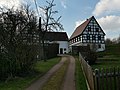 Wohnstallhaus, Seitengebäude, Scheune und Hofmauer eines Dreiseithofes