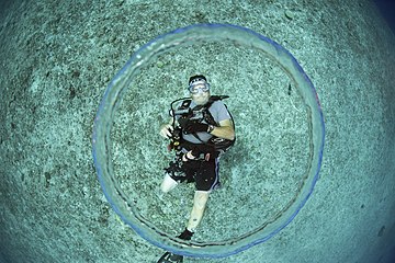 A scuba diver blows a bubble ring.