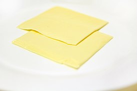 Два ломтика американского сыра на тарелке