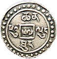 Moneda sino-tibetana de medio sho, fechada en el año 57 de la era Qianlong, anverso. Esta es un diseño de moneda que no fue autorizada por las autoridades imperiales de China, ya que tiene inscripciones en tibetano de ambos lados. En el siguiente año 58 (1793) se inició la emisión regular de monedas sino-tibetanas que tenían una inscripción en Chino en el anverso y una leyenda en tibetano en el reverso.