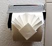 Pliage de rouleau de papier toilette dans une chambre d’hôtel.
