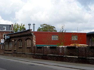 Alte Vorderwand der Maschinenhalle mit angebautem neuen Kantinengebäude; links im Hintergrund das Direktionsgebäude