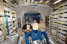 Original Jules Verne manuscripts displayed by crew inside the Jules Verne ATV Crew in ATV with Jules Verne manuscript.jpg