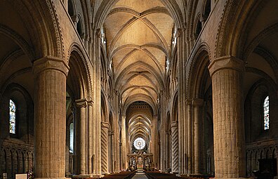The nave of Durham Cathedral has cylindrical piers with incised decoration, also found at Dunfermline Abbey, Scotland. Although Norman in character, the building has the first use of the pointed ribbed vault and flying buttresses.
