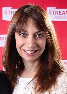 Femme brune avec d'immenses yeux bleus, un grand nez fin et une grande bouche