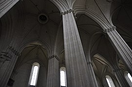 Vue en contre-plongée des piliers et des voûtes d'une église.