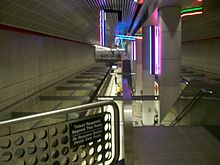 Œuvre lumineuse dans une station des lignes rouge et violette, vue depuis le niveau supérieur au quai.