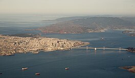 Utsjoch oer it noardwestlike part fan 'e Baai fan San Francisco, mei op 'e foargrûn de Bay Bridge en fierderop en mear nei lofts de Golden Gate Bridge.