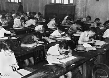 English: School children doing exams inside a ...