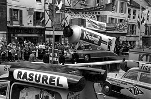 Toeschouwers bekijken de tourkaravaan met reclamewagens in 1958