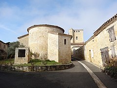 L'Église Saint-Jacques vue du chevet, ainsi qu'un puits au premier-plan et le château de Rouillac en arrière-plan.