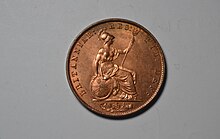 Photograph of the back side of a copper half-penny showing a seated woman dressed as a warrior