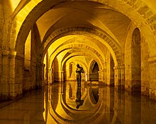 Flooded crypt beneath Winchester Cathedral, featuring Anthony Gormley's sculpture 'Sound II'