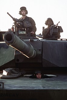 A commander (left) and loader man their 12.7 mm M2HB and 7.62 mm M240 machine guns of their 105 mm-armed M1. M1 Abrams 1981 Gunner and Coax M240.jpg