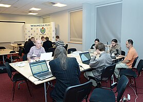 Na pierwszym planie grupa debatująca nad Wikibooks