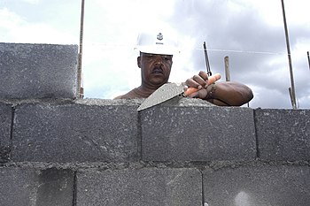 LIGAO, Philippines (June 26, 2007) - Senior Chief Builder James Brooks, attached to Naval Mobile Construction Battalion 7, carefully places mortar on a concrete block on a house being built in support of Pacific Partnership 2007. More than 50 Sailors contributed to the project with an aim to complete 35 new houses. A detachment of Seabees from NMCB-7 is attached to amphibious assault ship USS Peleliu (LHA 5) to assist the Philippine government in selected construction and engineering projects. U.S. Navy photo by Mass Communication Specialist Seaman Matthew Jackson .