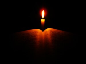 English: Bible in candlelight.