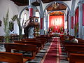 Interior de la iglesia en tiempo litúrgico de Semana Santa, con colgaduras que ocultan los retablos.