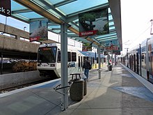 The platform of Portland Airport station; a two-car train awaits passengers to board with it doors open