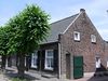 Huis onder een zadeldak tussen zijtopgevels met vlechtingen