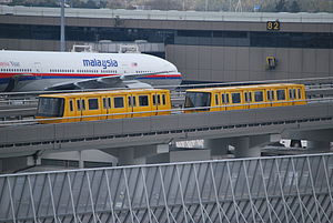 The Narita Airport Terminal 2 Shuttle System in March 2008 with a Malaysian airline aircraft behind