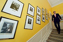 The portraits of former prime ministers line the staircase of 10 Downing Street, with then United States Secretary of State John Kerry walking past them (2016). Secretary Kerry Walks Past Portraits of Former Prime Ministers in No. 10 Downing Street in London (27795566993).jpg