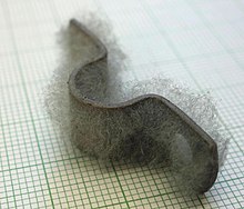 Pièce métallique recouverte d'une barbe ayant un aspect de duvet.