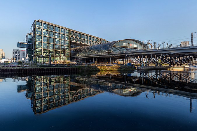 從東南方向看向柏林火車總站，其建築物倒映於洪堡港（德语：Humboldthafen）的水面上。車站大樓由建築師邁因哈特·馮·格爾坎（德语：Meinhard von Gerkan）設計，並於2006年5月26日正式啟用。