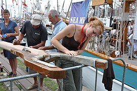 Le travail des gabières et gabiers est aussi d'entretenir les pièces de gréements, ici une corne de brigantine au Sail Amsterdam en 2010.