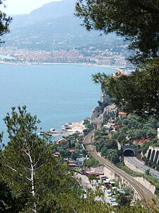 À Grimaldi, la France vue d'Italie. Au premier plan à droite, on voit la route côtière principale (Corso Europa in Frazione Grimaldi). À gauche de celle-ci, la voie ferrée transfrontalière. En arrière-plan, on aperçoit la ville de Menton et son Vieux Port (à gauche sur la photographie).