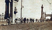 De peloton of the 1929 Ronde van Vlaanderen, passing a bridge in Ostend