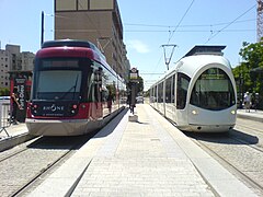 À gauche, une rame Rhônexpress; à droite, une rame Citadis de la ligne T3 au quai d'arrivée.