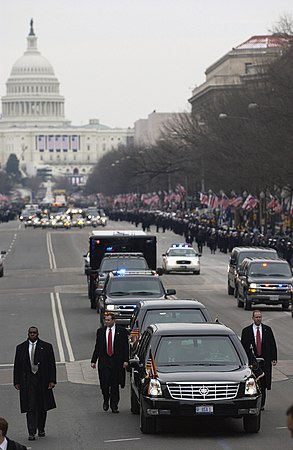 "USA 1" מוקפת באנשי השירות החשאי, במהלך נסיעתה האיטית בוושינגטון, בעוד המוני צופים ומריעים ומנופפים לשלום לצד הדרך. 20 בינואר 2005, לאחר השבעתו של ג'ורג' בוש הבן לקדנציה השנייה שלו